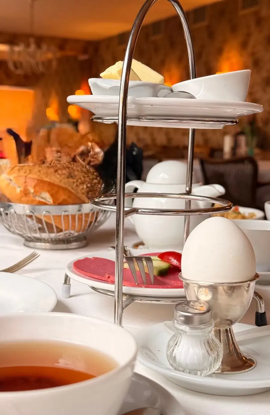 Etagere mit Gebäck, weichem Ei und Brötchenkorb im Café