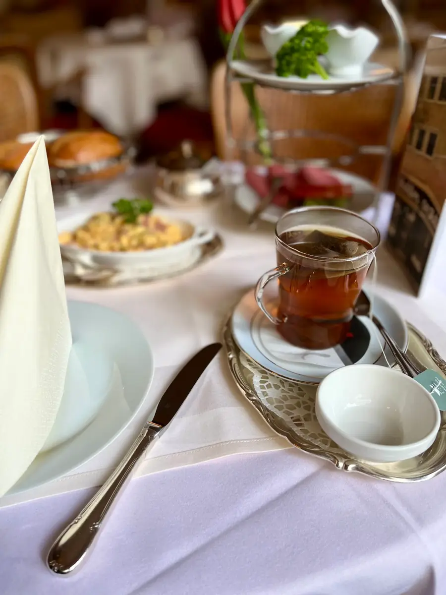 Gedeck mit Rührei, Tee und silbernem Milchkännchen im Café Wahlen