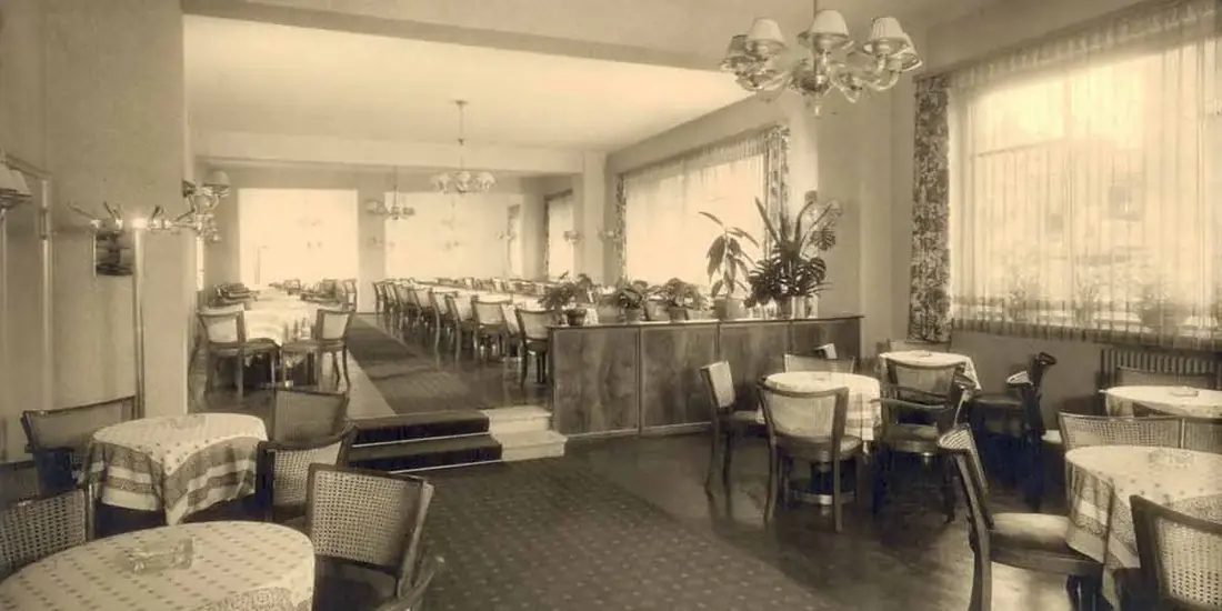 Heller Café-Saal mit weiß eingedeckten Tischen und Sesseln, historische Aufnahme
