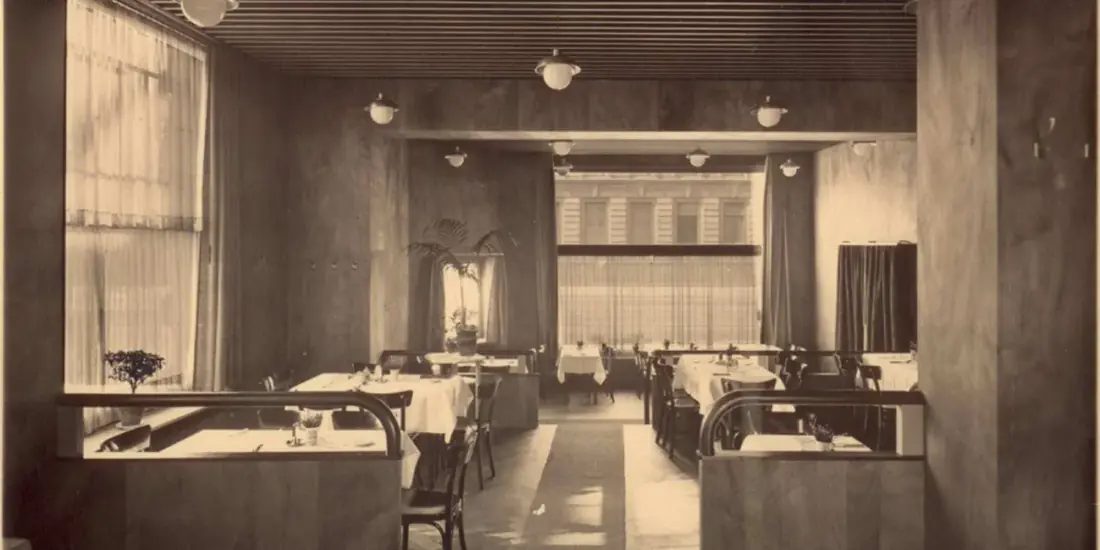 Café-Saal mit Vorhängen, Wandleuchten und gedeckten Tischen