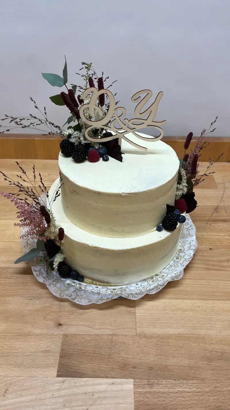 Zweistöckige Torte in Weiß mit Trockenblumen und goldenem Schriftzug