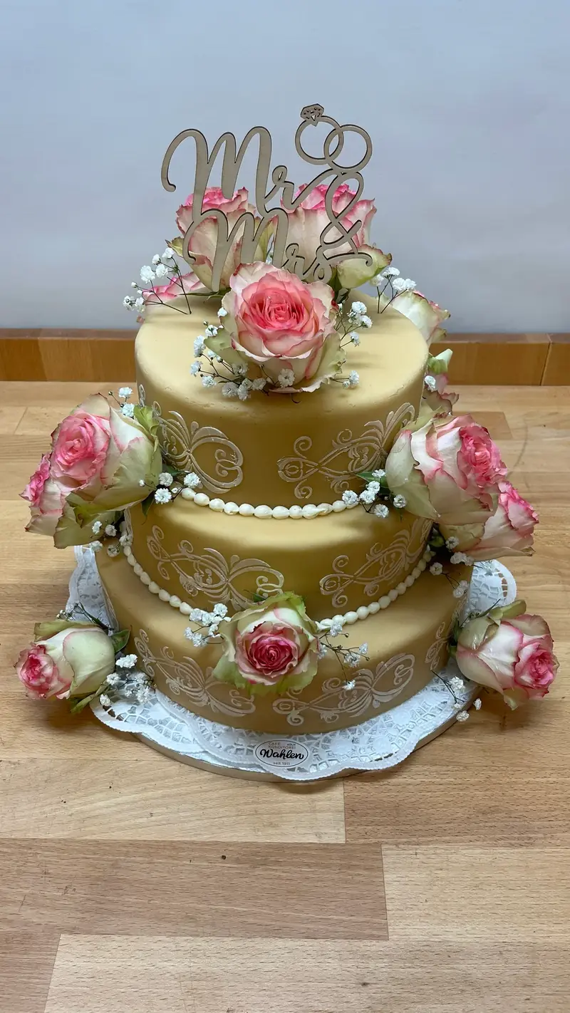 Zweistöckige Torte mit Blütenkranz und Mr-and-Mrs-Aufsatz