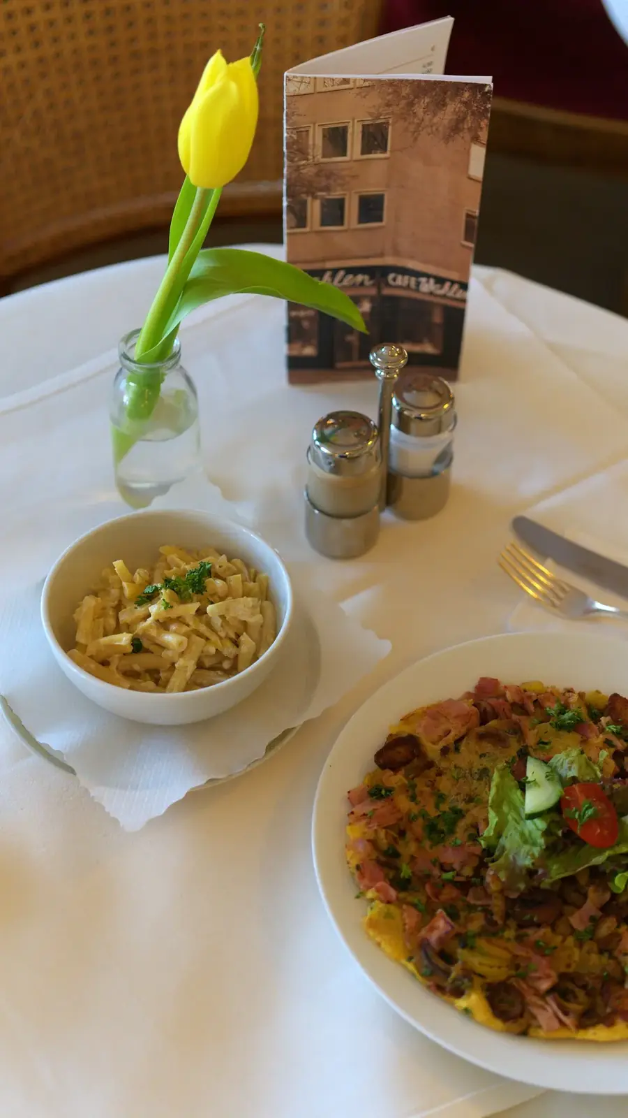 Herzhaftes Bauernomelett mit einer Tasse Suppe auf gedecktem Tisch