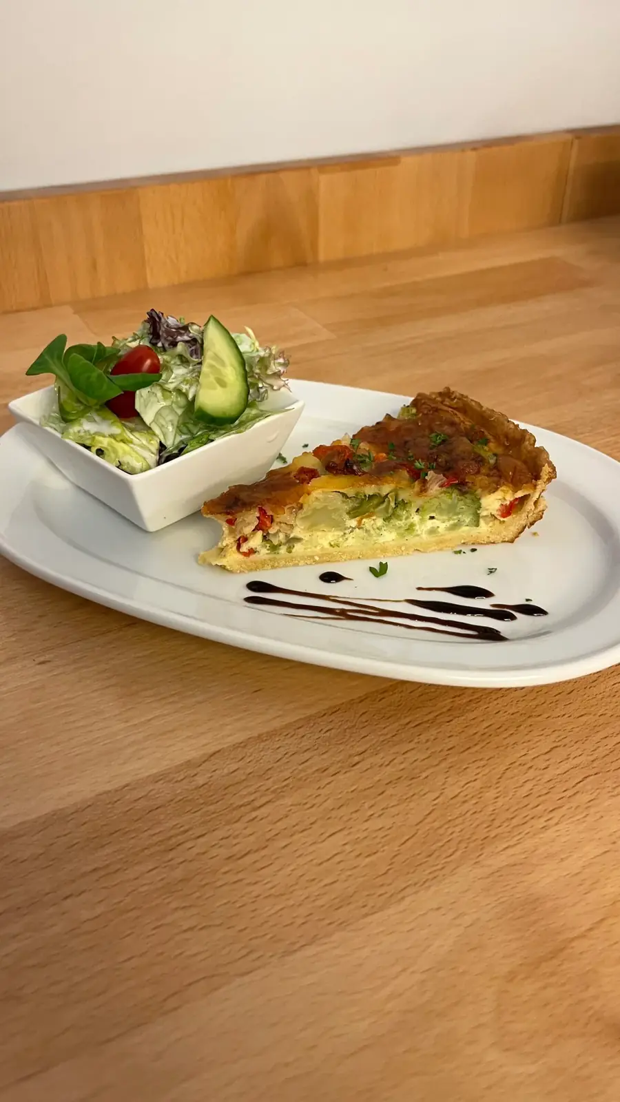 Stück Quiche mit frischem Salat auf einem Teller im Café Wahlen