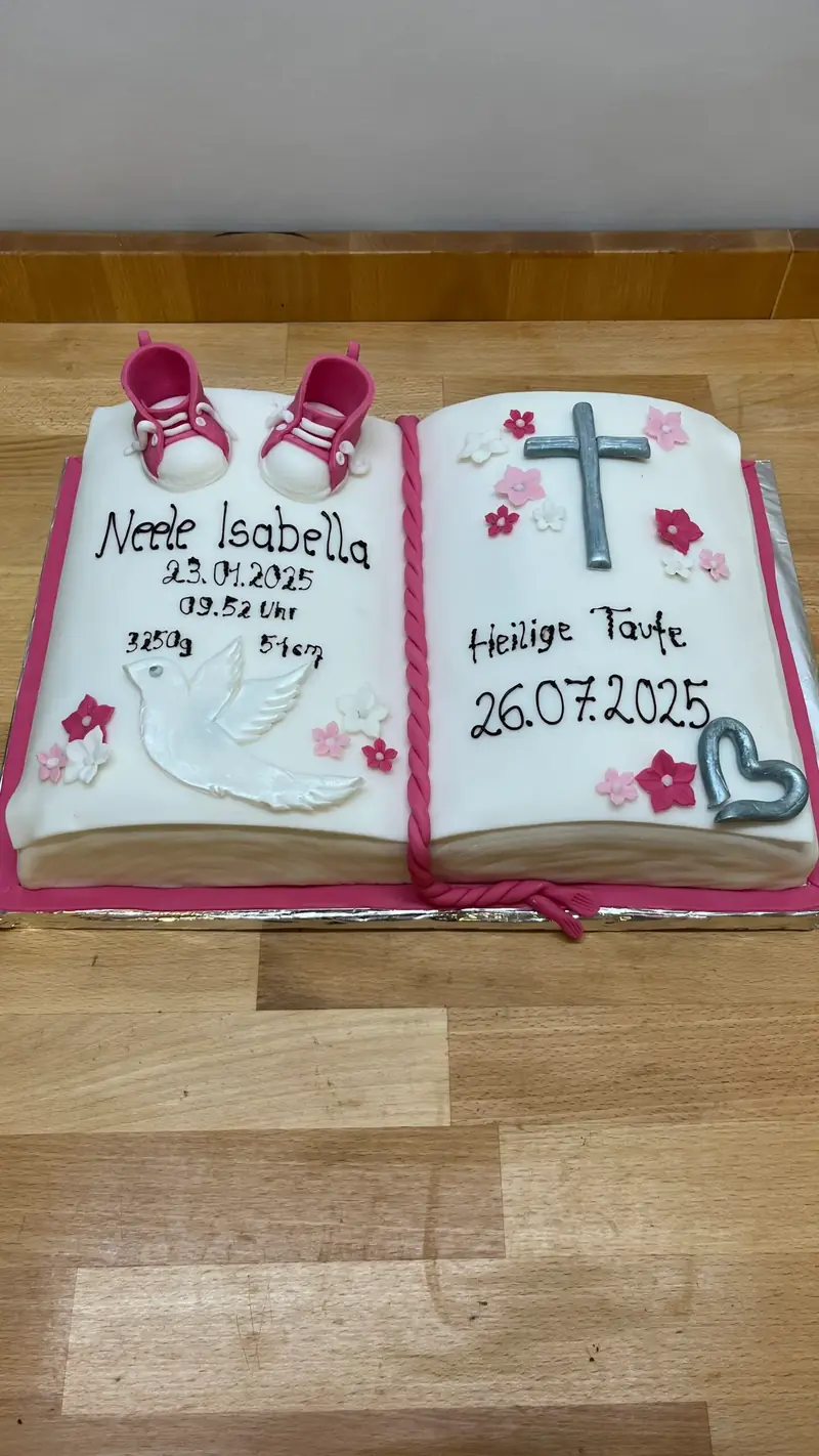 Torte in Buchform mit Kreuz und handgeschriebenem Schriftzug